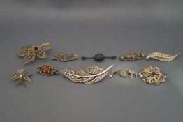A collection of ten silver and silver coloured brooches,