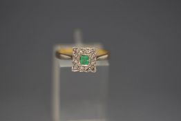An emerald and diamond ring, stamped '18ct', the square cut stone enclosed by twelve single cuts,