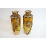 A pair of Japanese earthenware vases each decorated in gilt and enamels with an owl perched on a