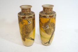 A pair of Japanese earthenware vases each decorated in gilt and enamels with an owl perched on a