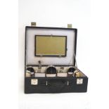 A 1930s Gentleman's dressing case, containing various plated and black painted jars,
