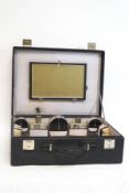 A 1930s Gentleman's dressing case, containing various plated and black painted jars,