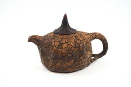 A Chinese earthenware teapot and cover, with scale-like pattern all-over, stamped to underside,