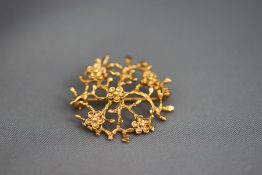 A 9ct gold brooch, in the form of Prunus branches and flowers, 3.3 cm diameter, 5.