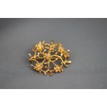 A 9ct gold brooch, in the form of Prunus branches and flowers, 3.3 cm diameter, 5.