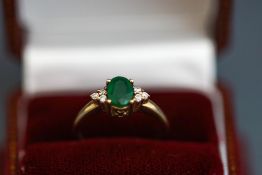 An emerald and diamond ring, stamped '9K',
