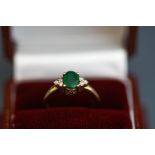 An emerald and diamond ring, stamped '9K',