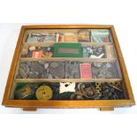 A cigar display box containing various collectors' items, including fossils, tins, carvings, coins,
