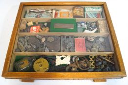 A cigar display box containing various collectors' items, including fossils, tins, carvings, coins,