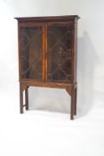 An Edwardian mahogany display cabinet with astragal glazed doors enclosing three shelves,