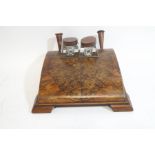 An Art Deco walnut desk ink stand with two glass inkwells and pen holders,