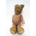 A large straw filled mohair teddy bear with moveable joints,