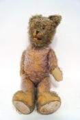 A large straw filled mohair teddy bear with moveable joints,