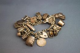 A silver bracelet, of curb links with charms attached,