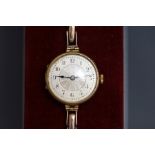 A lady's 9 carat gold wristwatch, with coin milled edge to the hinged case,
