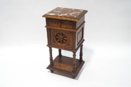 A Victorian oak bedside cupboard with single drawer, profusely carved all over,