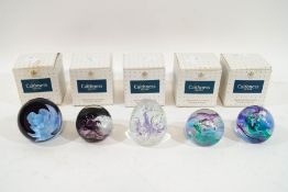 Five Caithness paperweights: 'White Rose, 'Moonbeam' and three variations of 'Mooncrystal',