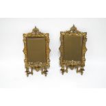 A pair of ornate pierced brass mirrored wall sconces with bevelled glass,