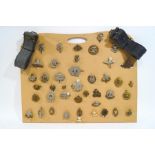 A collection of various military cap badges and a military cap,