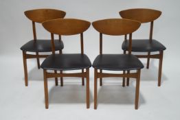 A set of four 1960's teak chairs with curved backs and black vinyl seats