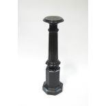 A serpentine marble torchere, the carved fluted column upon an octagonal stepped base,