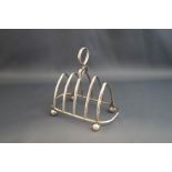 A silver toast rack, Birmingham 1926, the four division rack on ball supports, 12 cm long, 117 g (3.