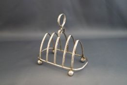 A silver toast rack, Birmingham 1926, the four division rack on ball supports, 12 cm long, 117 g (3.