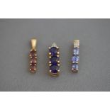 A 9 carat gold three stone sapphire pendant,