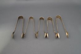 A collection of four silver sugar tongs; 63 g (2 troy ozs) gross;
