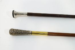 Two walking canes with decorative white metal handles