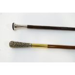 Two walking canes with decorative white metal handles