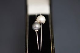 A pair of single stone cultured pearl and diamond torc wire bangles, stamped '750',