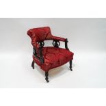 An Edwardian tub armchair with pierced ebonised frame,