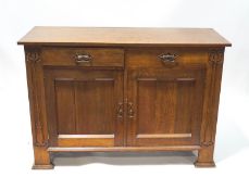 An Arts & Crafts oak dresser base with two drawers over a cupboard,