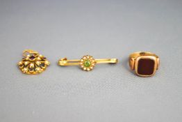 A 9 carat gold cornelian signet ring; a peridot and seed pearl cluster bar brooch;