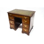 A George III and later mahogany kneehole desk, with green leather writing surface,