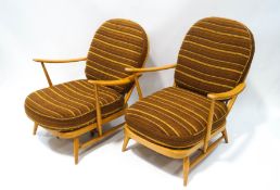 A pair of Ercol blonde wood stick back armchairs,