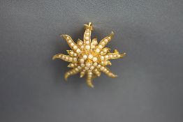 A sun in splendour seed pearl set pendant brooch, stamped '14K', 3.