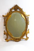 A carved giltwood frame wall mirror with trefoil shaped inner surround,