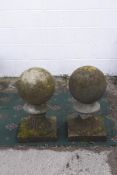 A pair of reconstituted stone weathered gate post spherical finials,