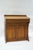 A pine clerks desk, with hinged lid above a cupboard base,