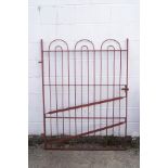 An iron gate, painted red, 152cm high x 118cm wide,