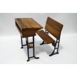 An early 20th century oak school desk with iron base, from Christ's Hospital,