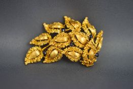 A gold leaf shaped brooch, marked '750', set with five small sapphires, 5.2 cm long, 15.