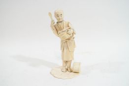 A late 19th/early 20th century Japanese figure of a robed figure holding a basket of food, 18.