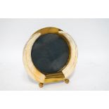 A warthog tusk and brass photograph frame, on ball feet,