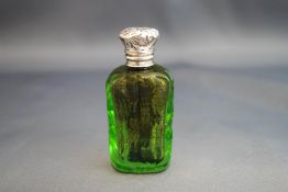 A Victorian green cut glass scent bottle, with silver coloured embossed hinged cover,