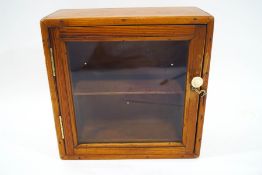 A small pine cabinet with glazed front,