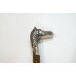 A walking stick with white metal horse's head