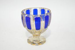 A Bohemian glass goblet, with panels of blue overlay and profuse gilt patterning,